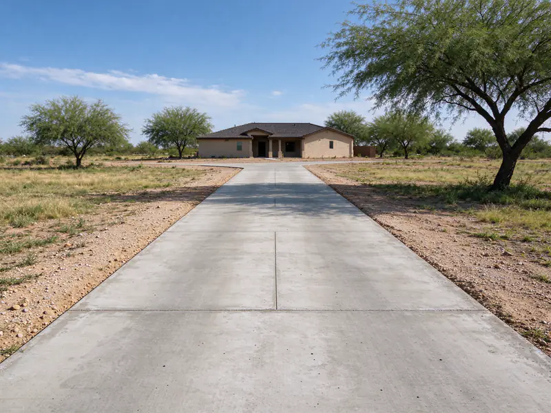 Finished concrete driveway with gravel shoulders on a rural Queen Creek lot