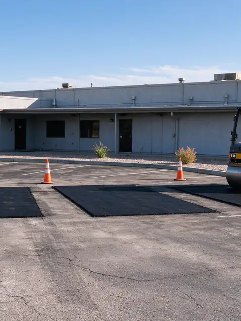 Three fresh saw-cut asphalt patches in the drive aisle of a Glendale parking lot